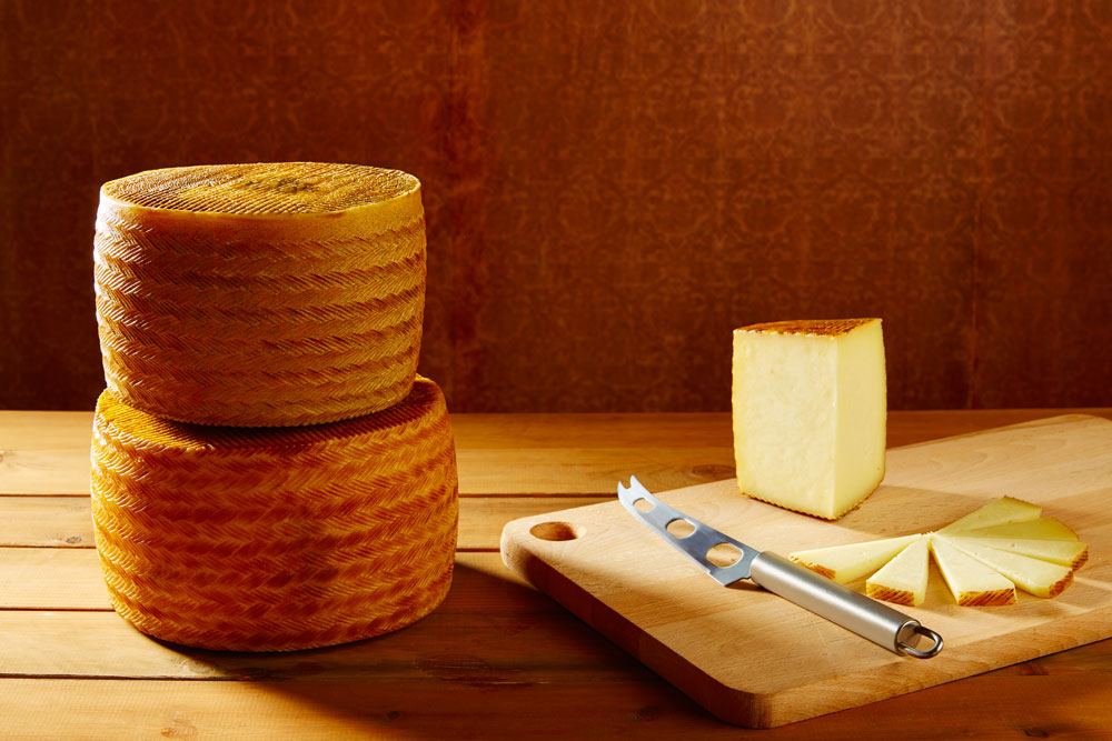 Sliced Aged Manchego and a knife on the chopping board