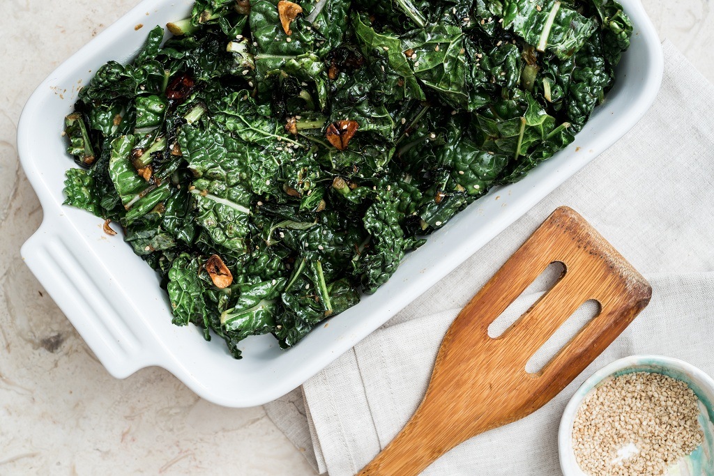 Braised kale on the plate and a spoon