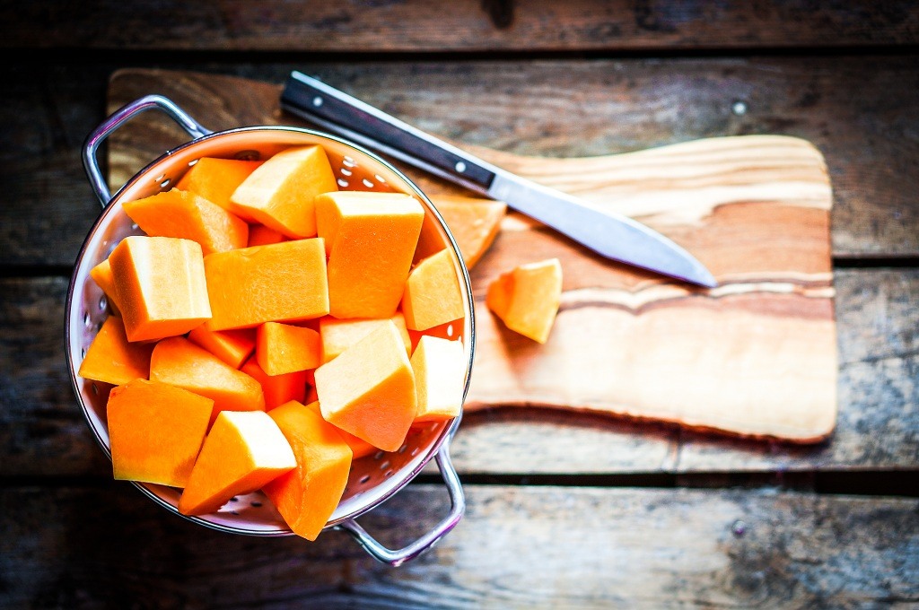 Pieces of Butternut Squash and a knife on the chopping board