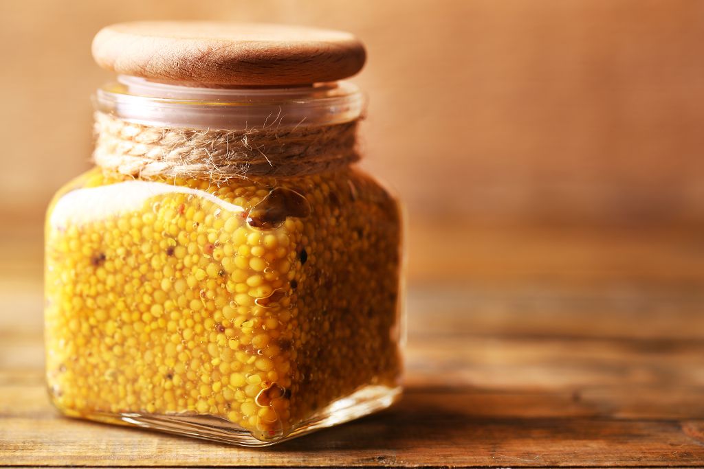 A jar of Dijon mustard on the table