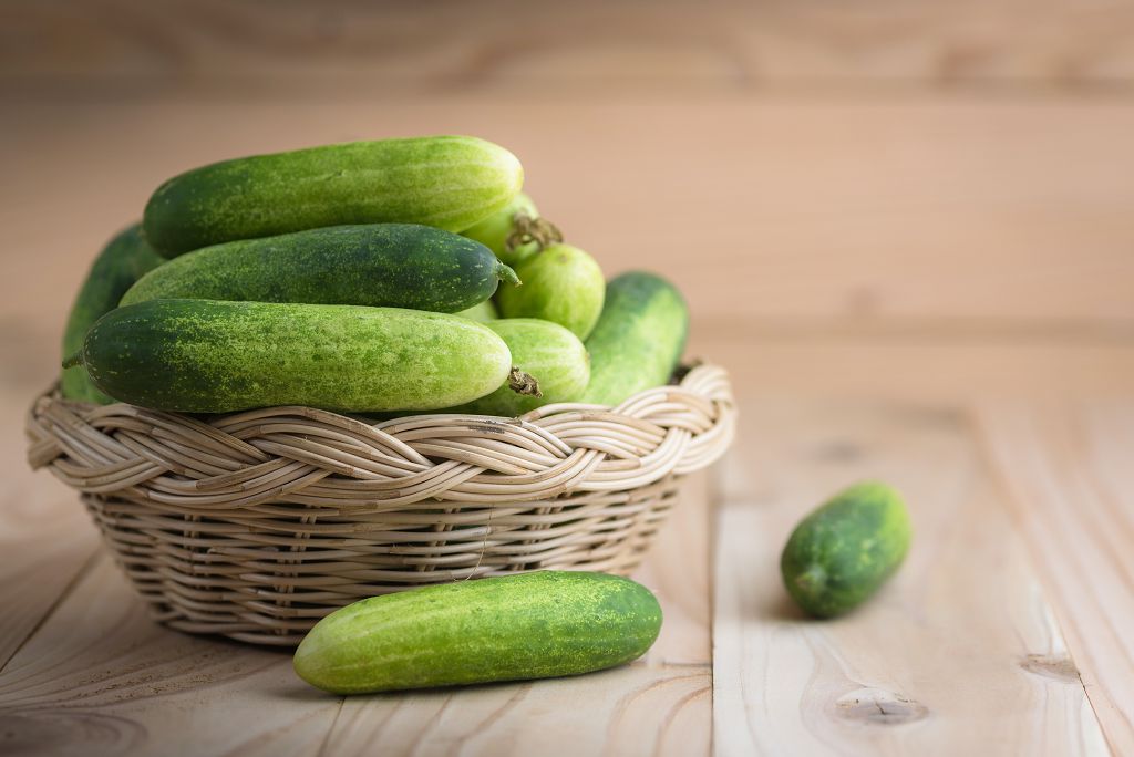 a basket of cucumbers and cucumbers on the table