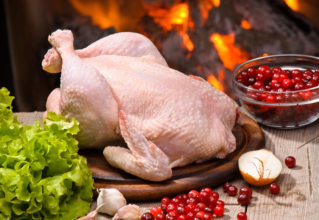 raw chicken on the chopping board and vegetables