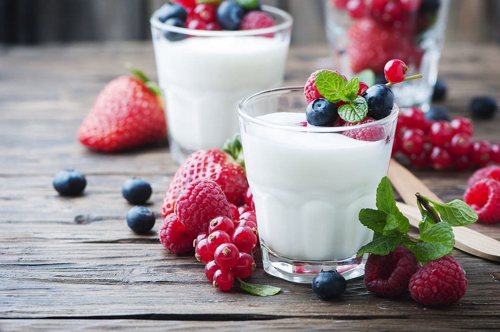 yogurt cups and fruit on the table