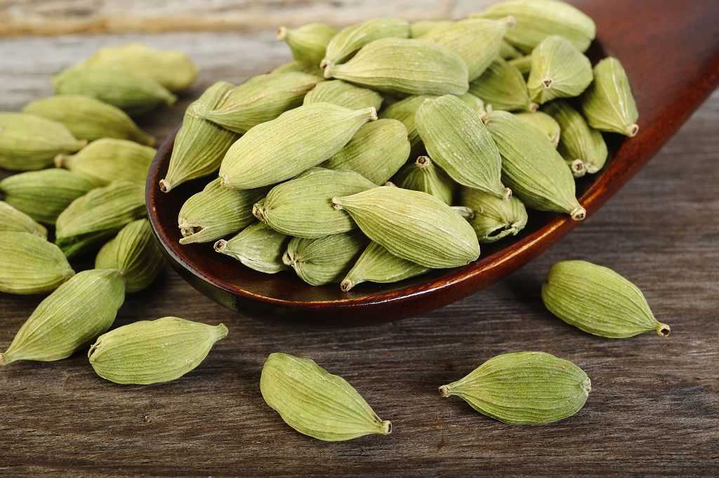 a spoon of cardamom and cardamom on the table