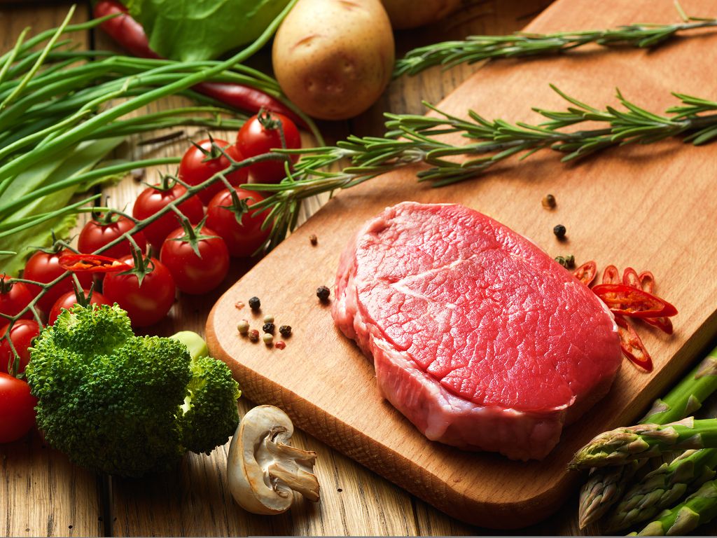 Beef Steak on the chopping board and vegetables