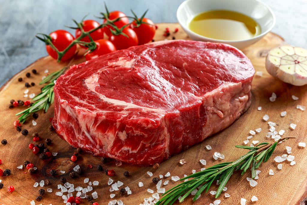 Beef Steak on the chopping board and vegetables