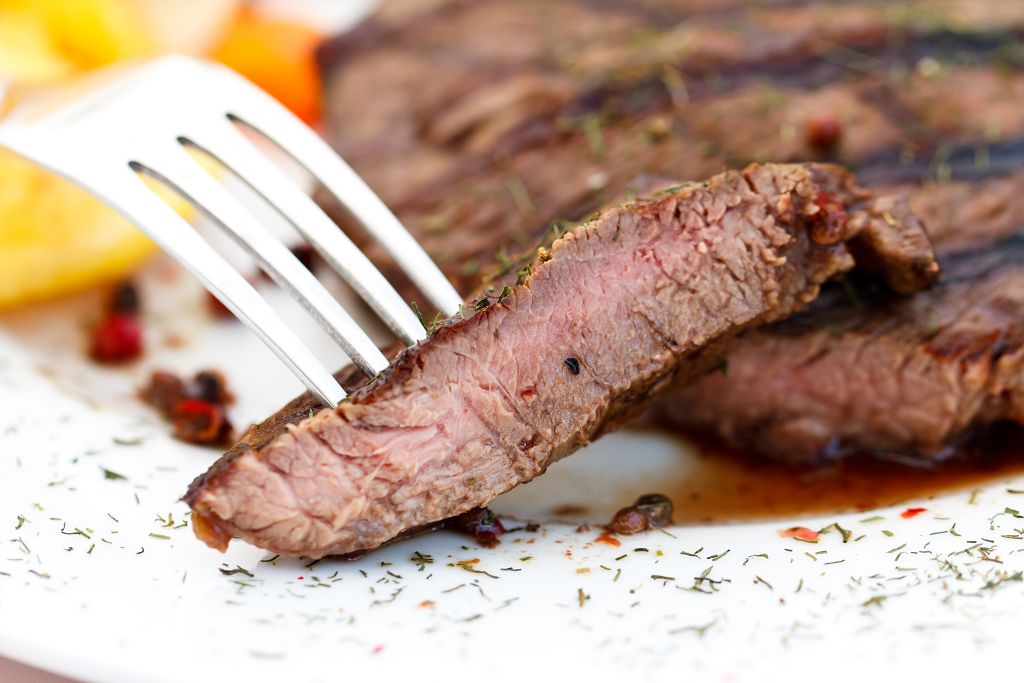 Slices of Beef Steak on the plate and a fork