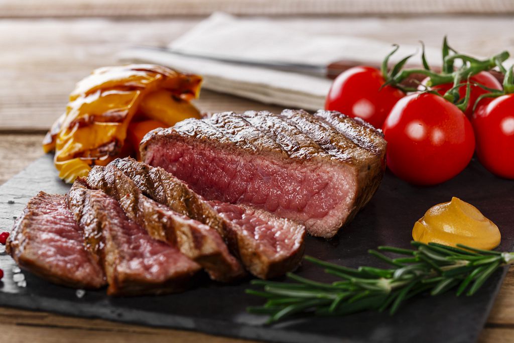 Slices of Beef Steak and tomatoes on the chopping board