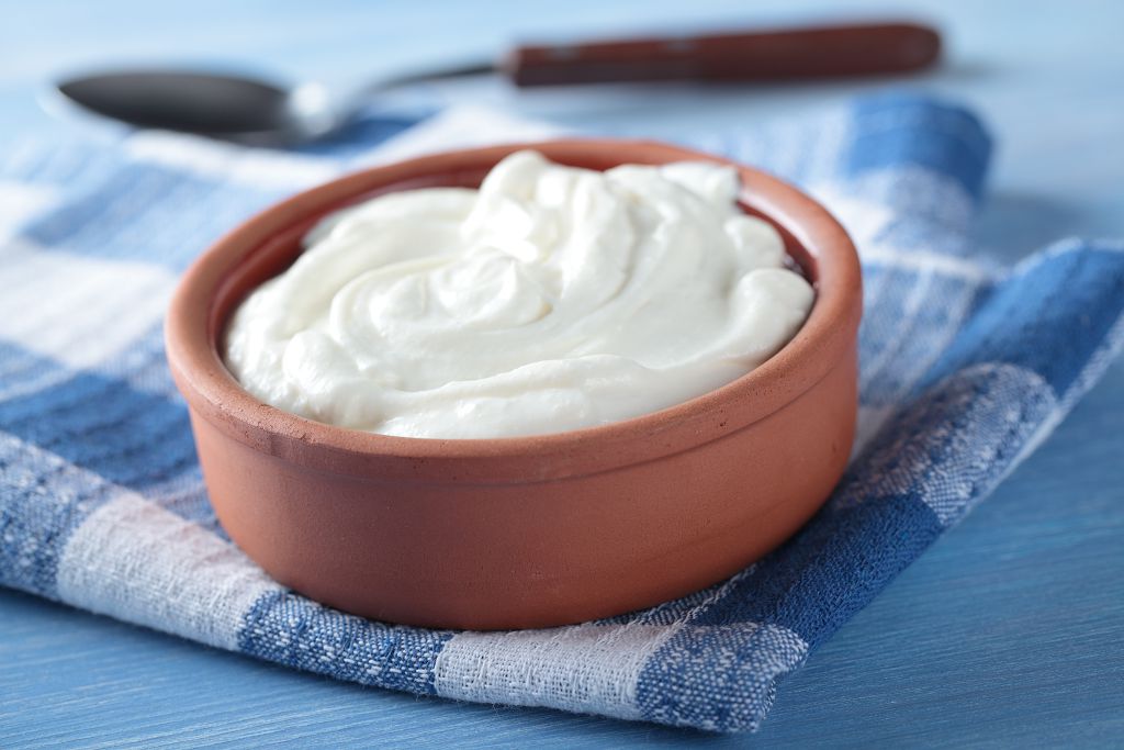 A cup of Greek yogurt and a spoon