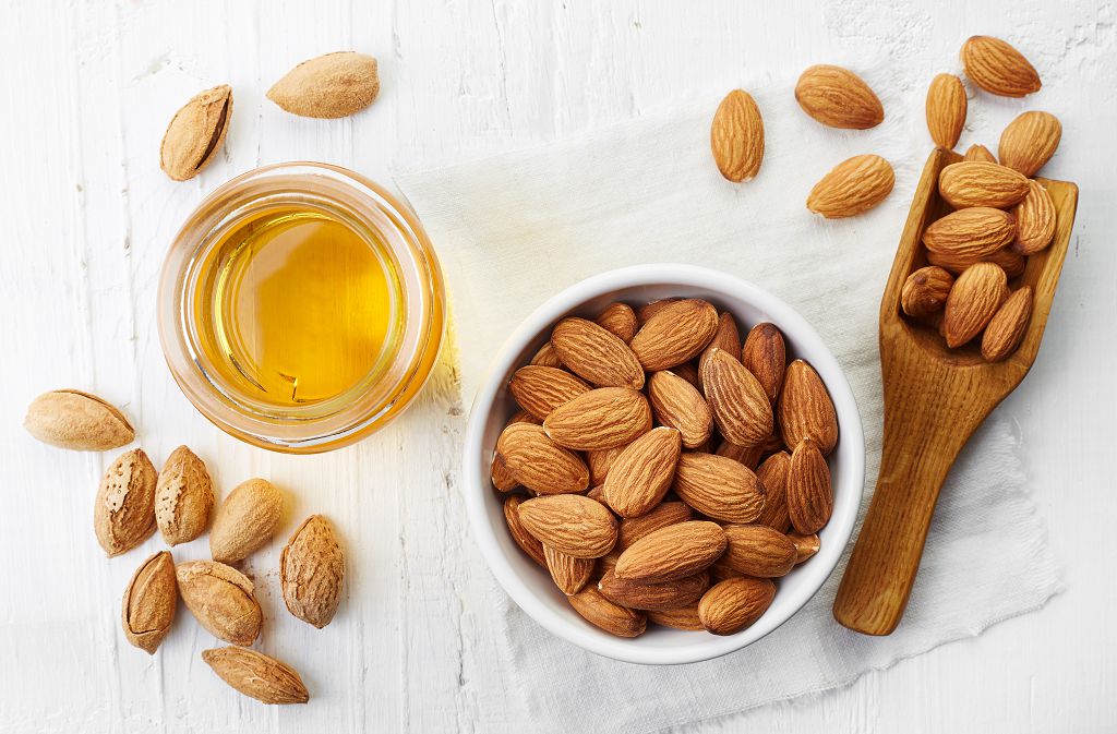 A bowl of Almonds, a spoon of Almonds and Almonds