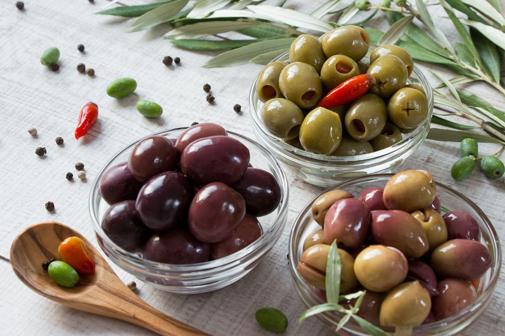 Bowls of Olives and a spoon of Olives