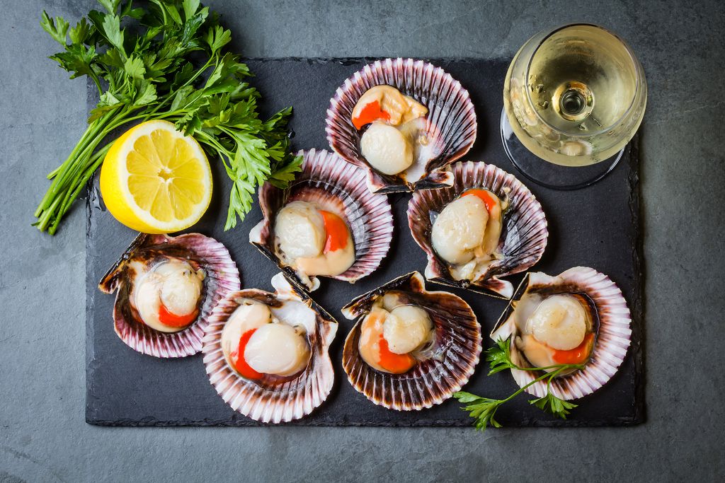 fresh Scallops, sliced lemon, vegetables and a cup