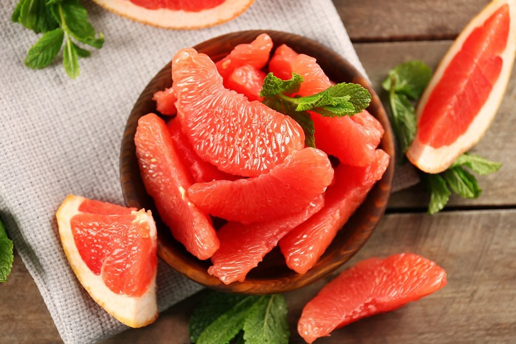 Slices of Grapefruits on the bowl and vegetables