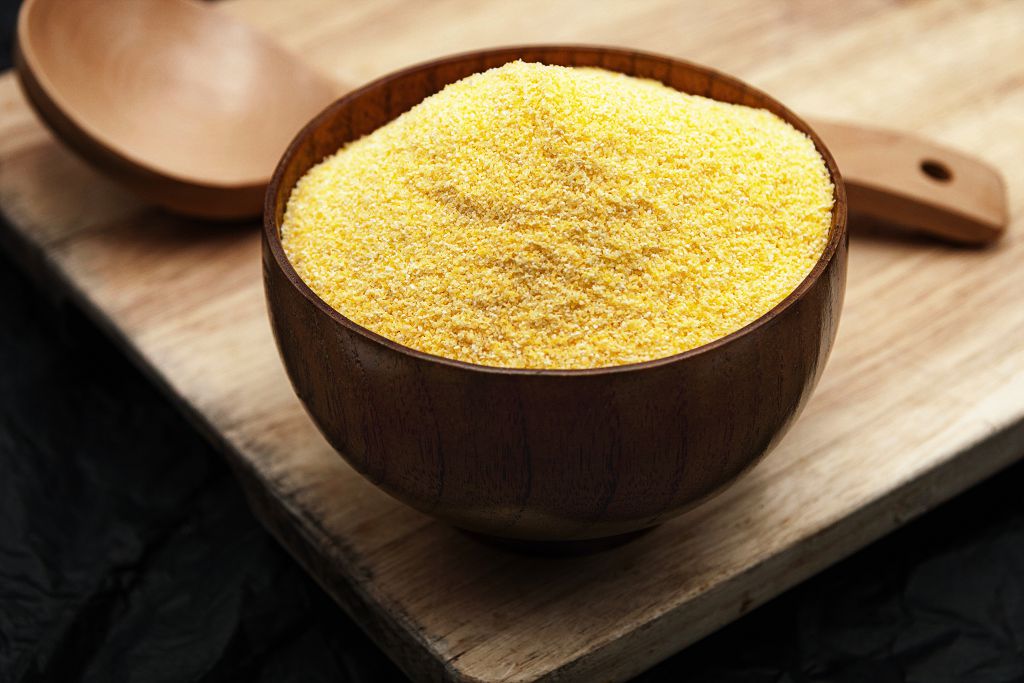 A huge bowl of Cornmeal and a big spoon on the table