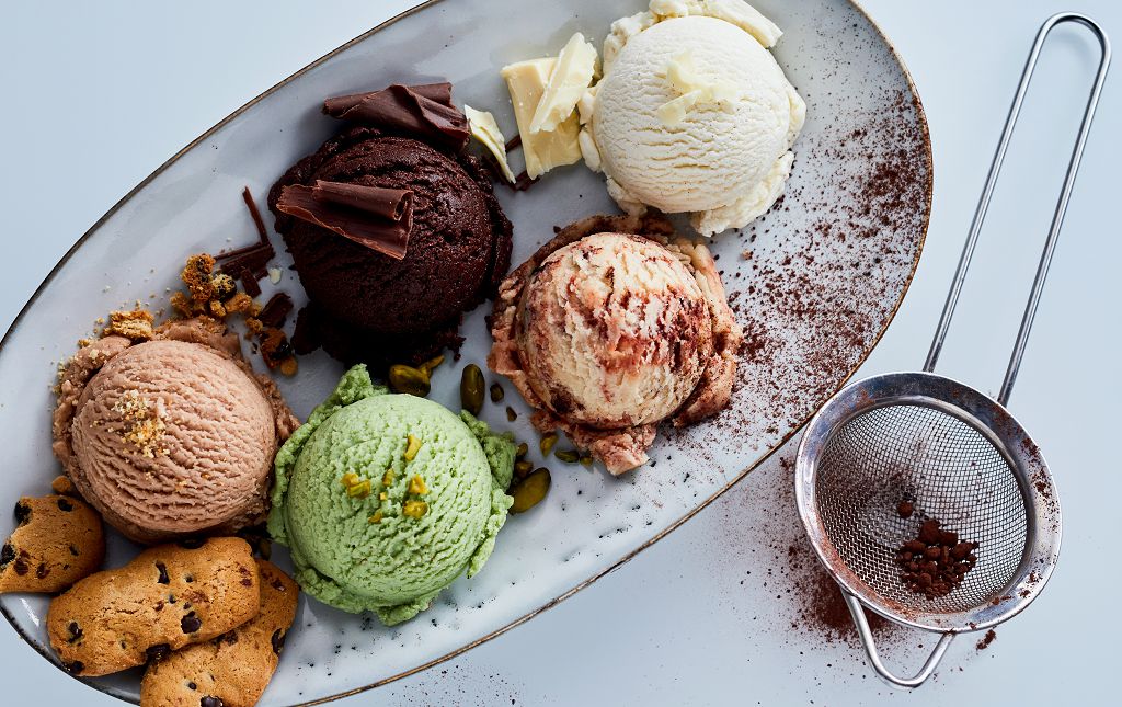 A plate of ice cream and a flour sifter on the table