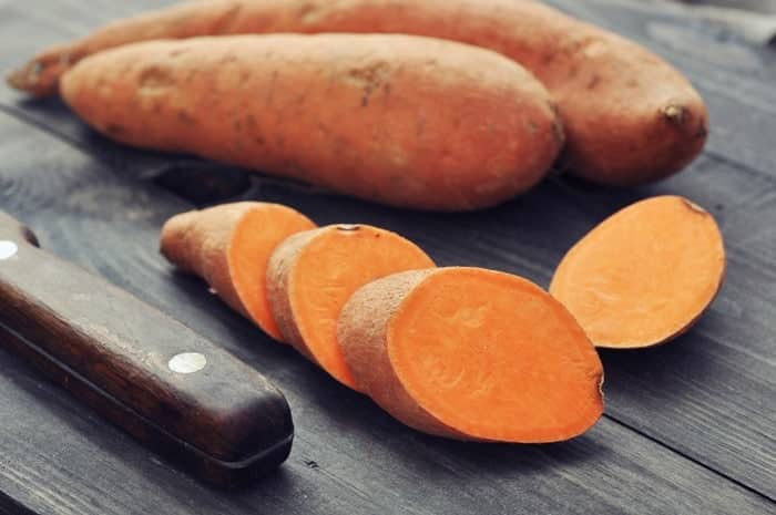 Sliced Raw Sweet Potatoes, a knife and Sweet Potatoes