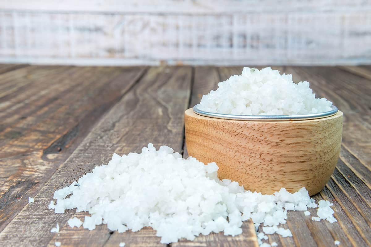 A bowl of sea salt and sea salt on the table