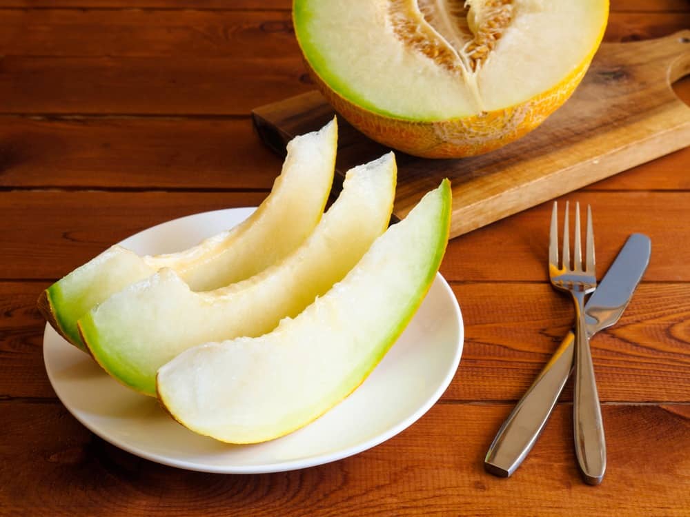 slices of honeydew melons on the chopping board and a plate of slices of honeydew melons