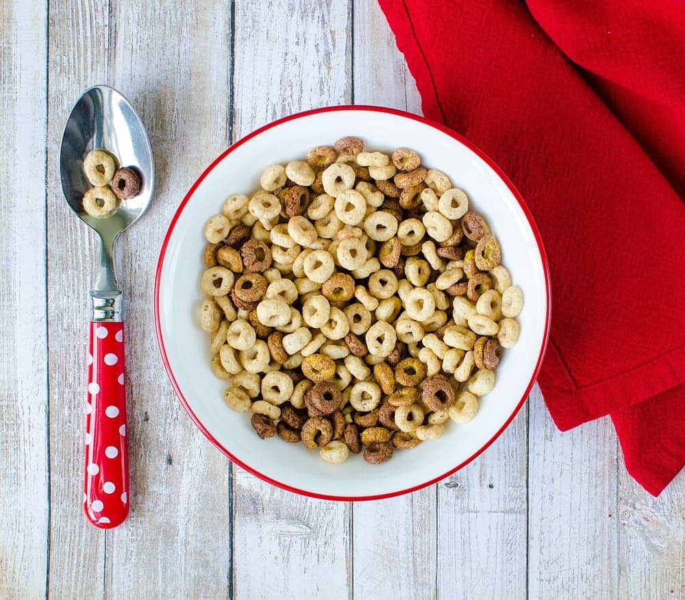 a bowl of Cheerios and a spoon on the table