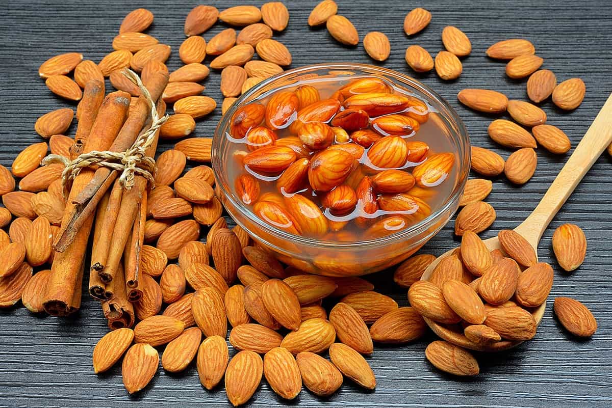 A bowl of almonds, a spoon of almonds and almonds