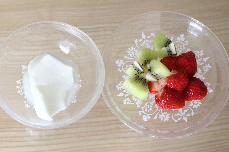 A bowl of Yoghurt and a bowl of fruits